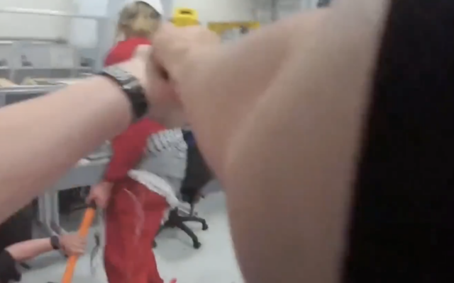 Une vidéo prise par une caméra corporelle,montre un  policier pointant un Taser sur un intrus, qui vient de frapper une agente avec une masse, sur le site d'Elbit UK à Bristol, en Angleterre,  le 6 août 2024, . (Capture d'écran : Quatrième chaîne)